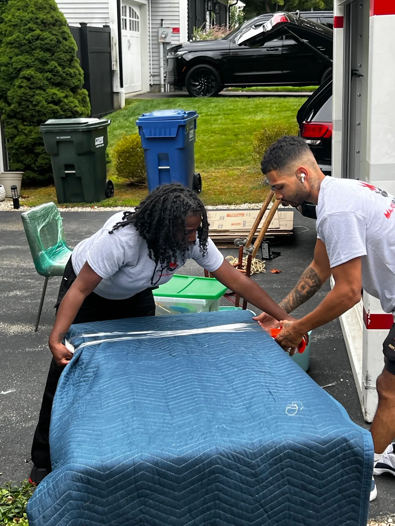 Major Movers crew protecting furniture with moving blankets and stretch wrap