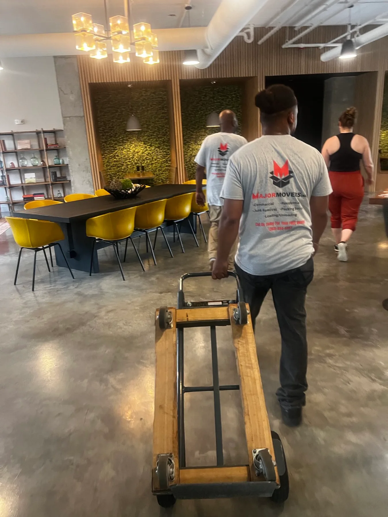 Major Movers crew moving office furniture with a four-wheel dolly